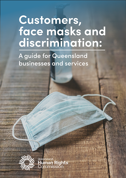 Front cover of the 'Customers, face masks and discrimination' guide for businesses and services. Colour photo of a disposable face mask on a raw timber table, with a small pump bottle of hand sanitiser behind it.